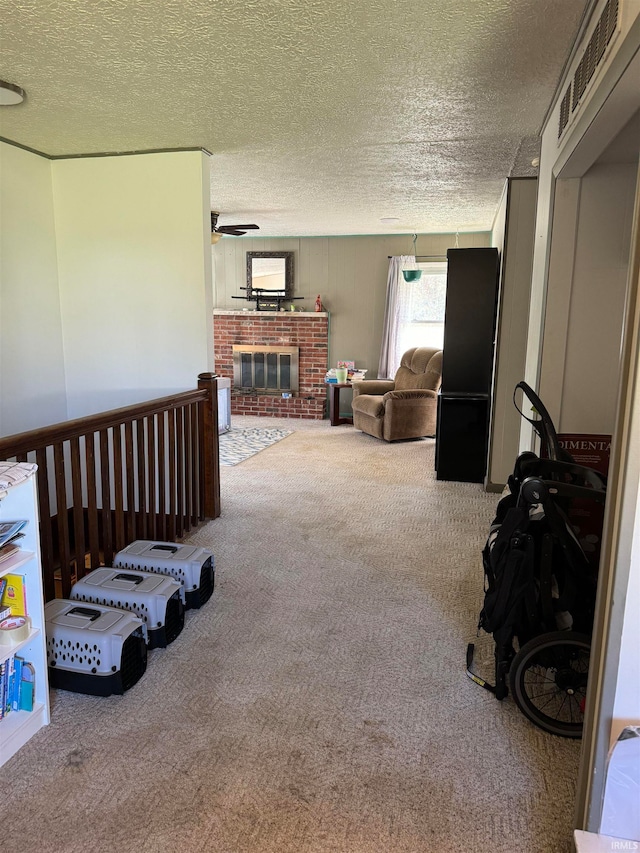 carpeted living room with a textured ceiling and a brick fireplace