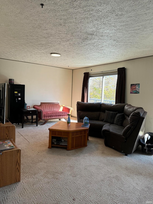 living room with carpet flooring, a textured ceiling, and wood walls