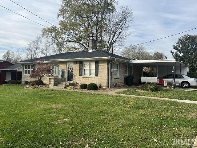 ranch-style house with a front yard and a carport