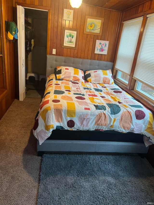 bedroom featuring carpet flooring and wood walls