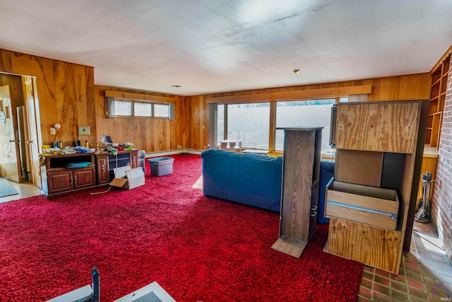 living room featuring wood walls and dark carpet