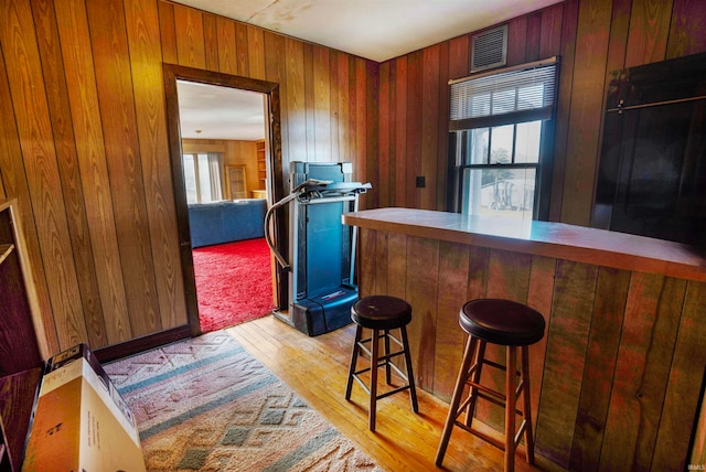 bar with wood walls and light hardwood / wood-style floors