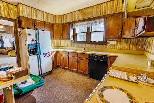 kitchen with black dishwasher, white fridge with ice dispenser, a healthy amount of sunlight, and sink