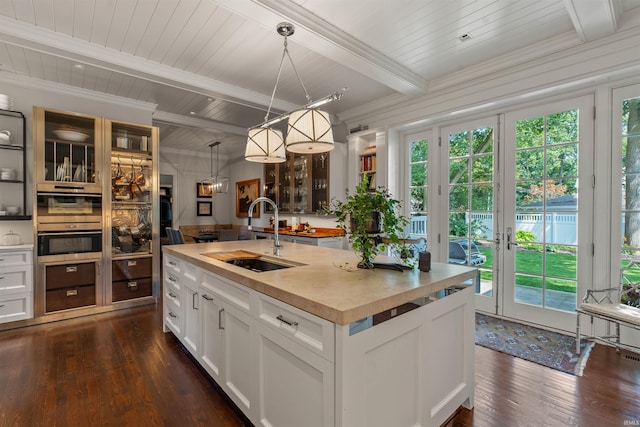 kitchen with plenty of natural light, decorative light fixtures, sink, and a kitchen island with sink