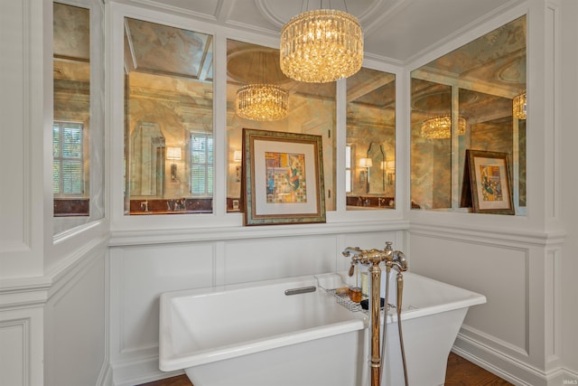 bathroom featuring ornamental molding, hardwood / wood-style floors, a tub, and an inviting chandelier