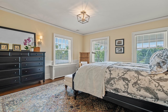 bedroom with radiator, dark hardwood / wood-style floors, and crown molding