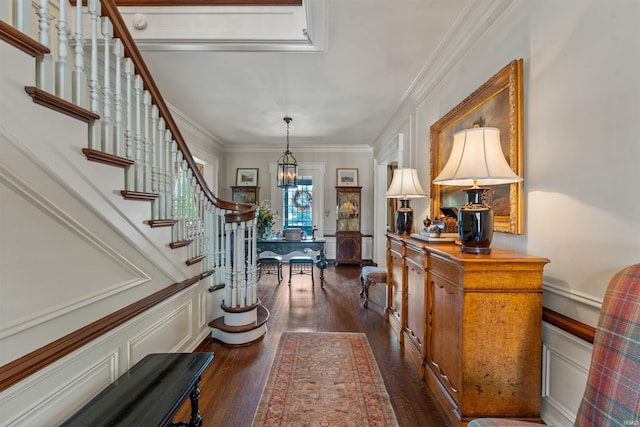 foyer featuring dark hardwood / wood-style flooring, a chandelier, and crown molding