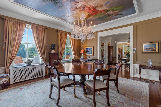 dining area with an inviting chandelier, wood-type flooring, and ornamental molding