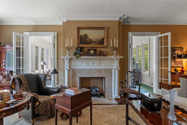 sitting room with a fireplace, a wealth of natural light, light hardwood / wood-style flooring, and crown molding