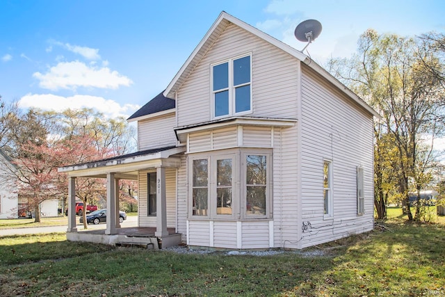 back of property featuring a porch and a lawn