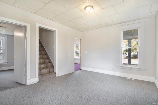 carpeted spare room with a paneled ceiling