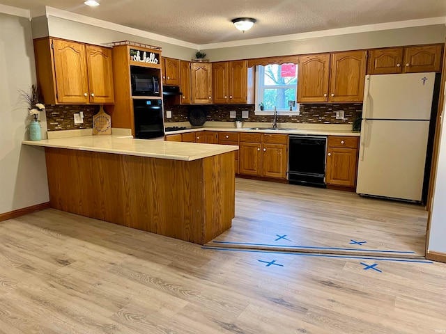 kitchen featuring kitchen peninsula, light wood-type flooring, a textured ceiling, sink, and black appliances