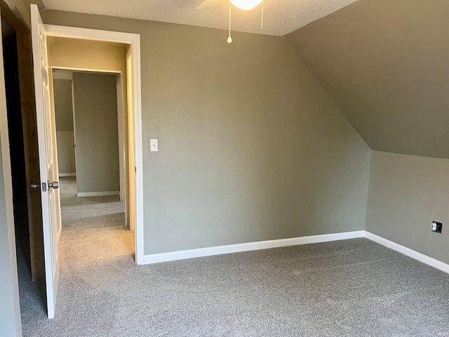 additional living space with lofted ceiling, ceiling fan, carpet floors, and a textured ceiling