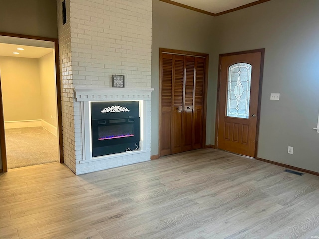 entryway featuring ornamental molding and light wood-type flooring