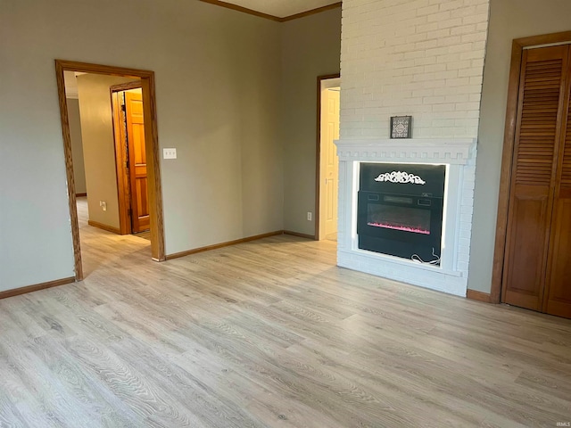 unfurnished living room featuring a fireplace, light hardwood / wood-style floors, and ornamental molding