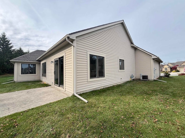 view of home's exterior featuring cooling unit, a lawn, and a patio area