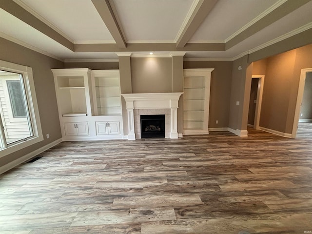 unfurnished living room featuring a fireplace, wood-type flooring, and crown molding