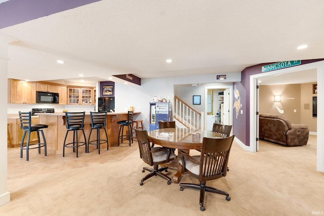 dining space featuring light carpet and indoor bar