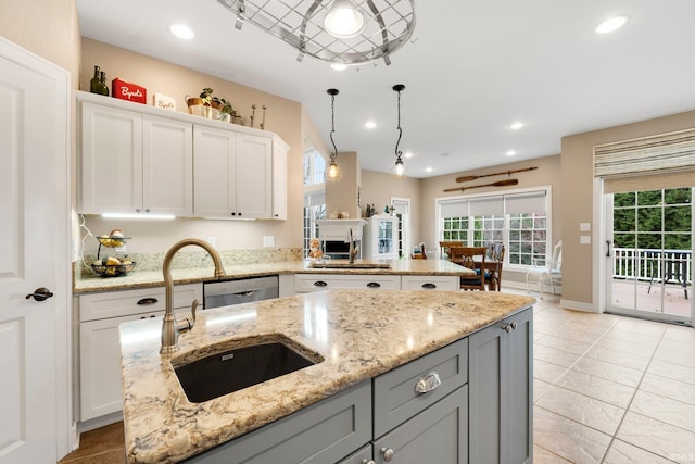 kitchen featuring white cabinetry, sink, pendant lighting, and light stone counters