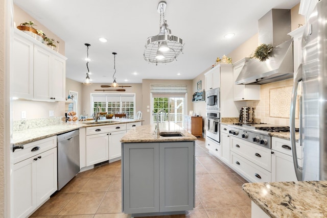 kitchen featuring white cabinetry, sink, stainless steel appliances, wall chimney range hood, and a kitchen island