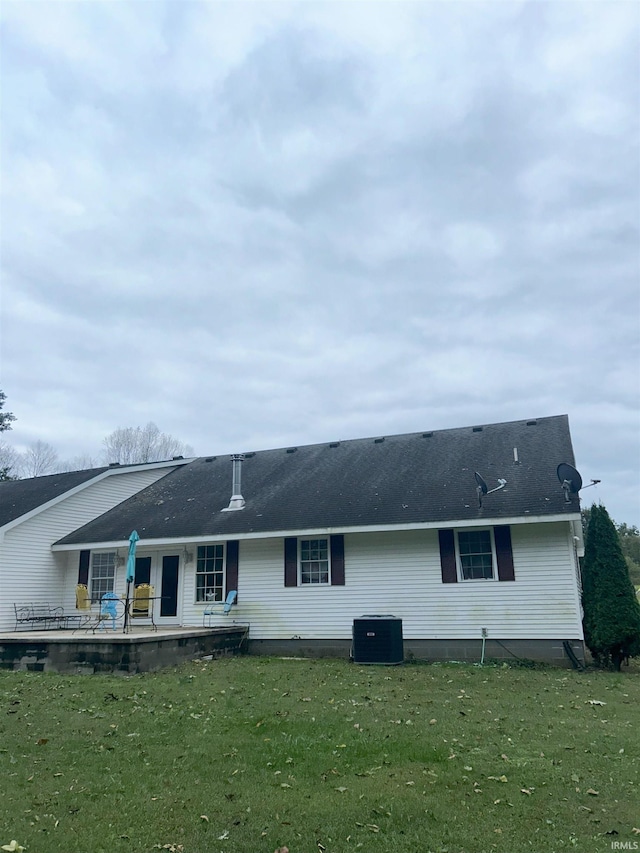 back of house with central air condition unit, a yard, and a patio