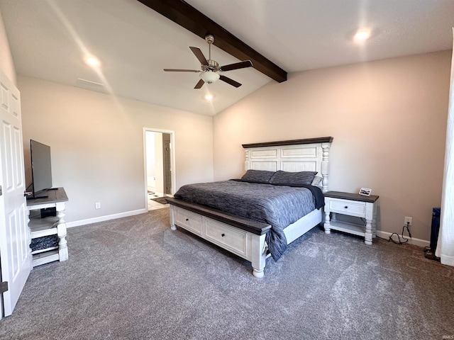 bedroom featuring ceiling fan, ensuite bath, lofted ceiling with beams, and dark carpet