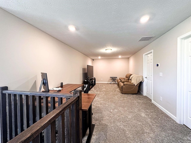 interior space featuring carpet flooring and a textured ceiling