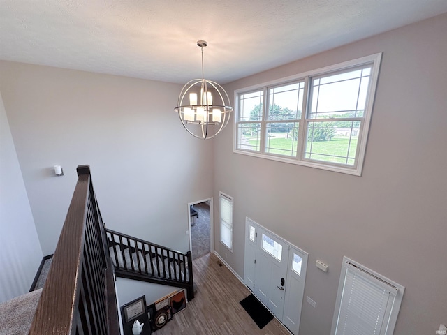 foyer entrance featuring hardwood / wood-style floors and a chandelier