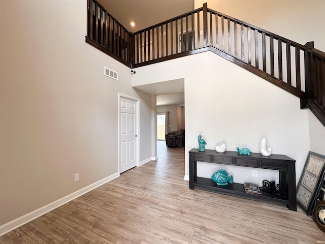 stairs featuring hardwood / wood-style floors and a high ceiling