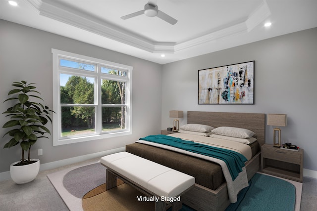 bedroom with a tray ceiling, crown molding, ceiling fan, and carpet floors