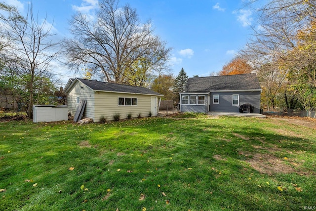 back of property with an outdoor structure and a yard