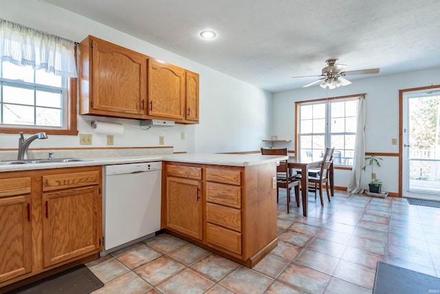 kitchen featuring light tile patterned flooring, sink, dishwasher, kitchen peninsula, and ceiling fan