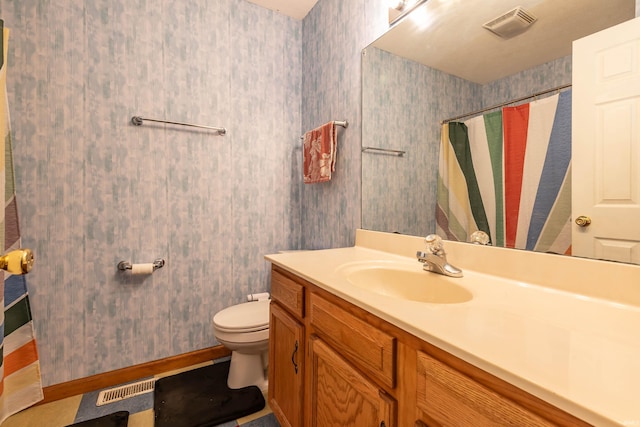 bathroom featuring curtained shower, vanity, and toilet