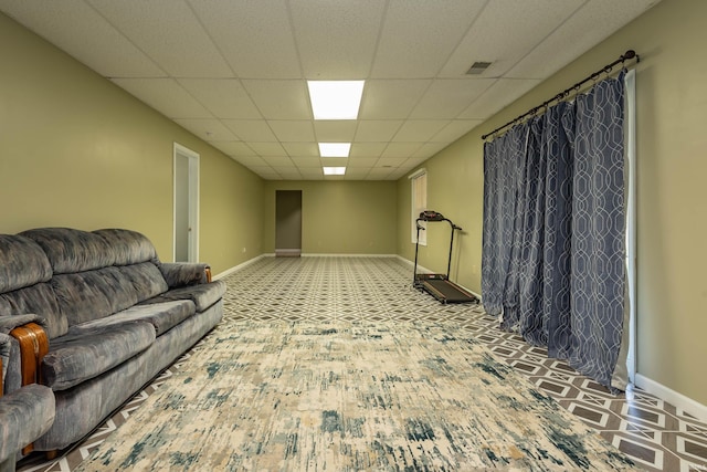 living room featuring a drop ceiling and light colored carpet