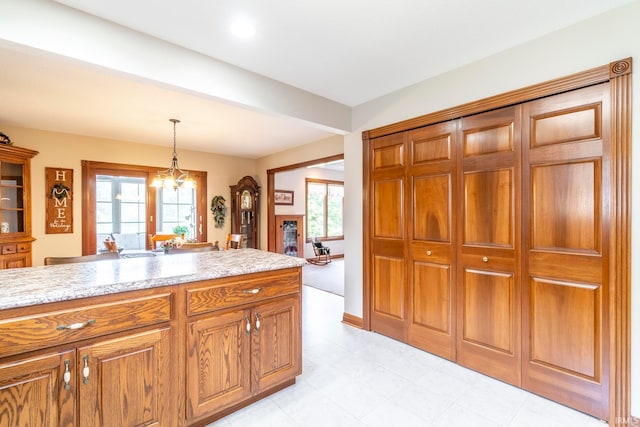 kitchen featuring light stone countertops, decorative light fixtures, and a notable chandelier