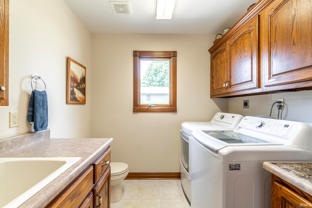 clothes washing area featuring light tile patterned floors, sink, and washer and dryer