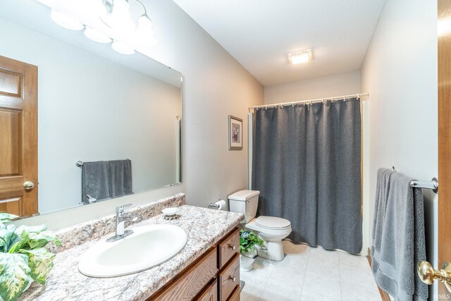 bathroom with toilet, a shower with curtain, vanity, and tile patterned flooring