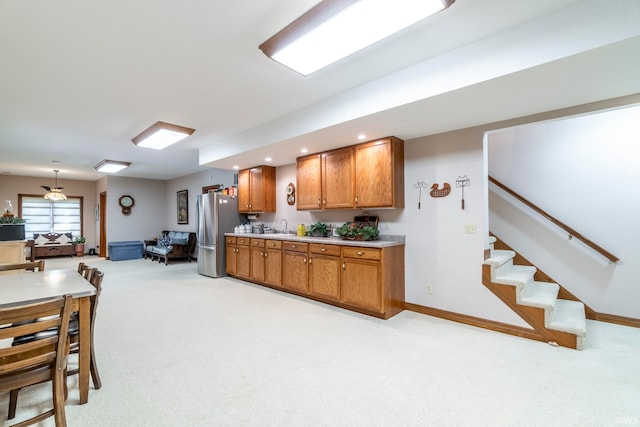 kitchen with stainless steel fridge, sink, pendant lighting, and light colored carpet