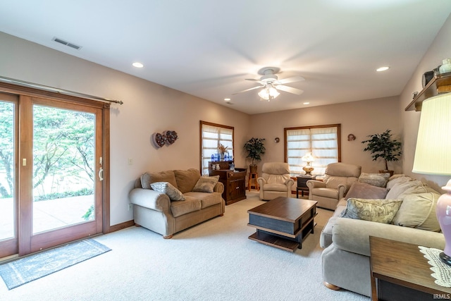 carpeted living room with ceiling fan