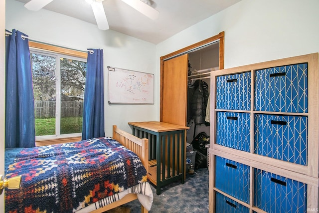 bedroom featuring dark colored carpet, ceiling fan, and a closet