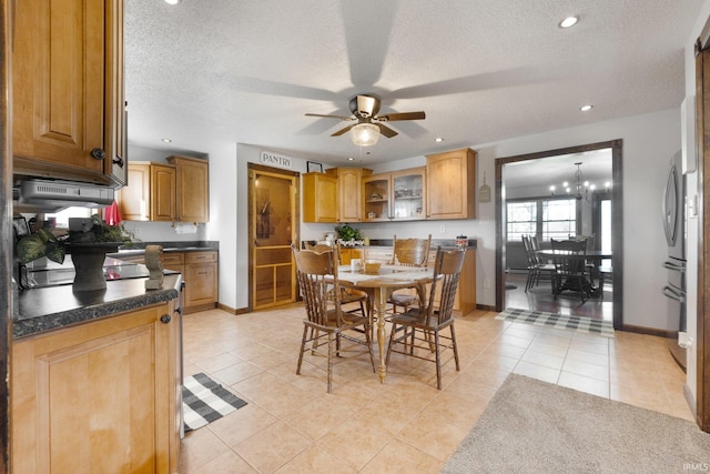 kitchen featuring range hood, a textured ceiling, light tile patterned floors, and ceiling fan with notable chandelier