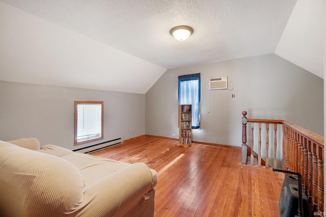 bonus room featuring lofted ceiling, hardwood / wood-style flooring, a healthy amount of sunlight, and a baseboard radiator