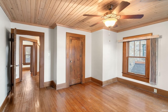 unfurnished bedroom featuring hardwood / wood-style flooring, multiple windows, wooden ceiling, and ornamental molding