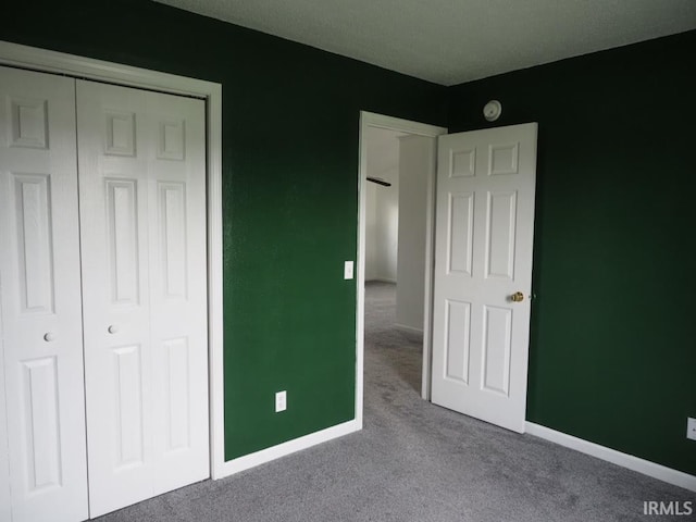 unfurnished bedroom with a closet and light carpet