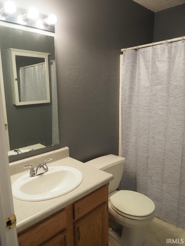 bathroom featuring vanity, toilet, and a textured ceiling