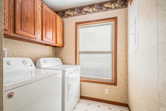 clothes washing area with cabinets and separate washer and dryer