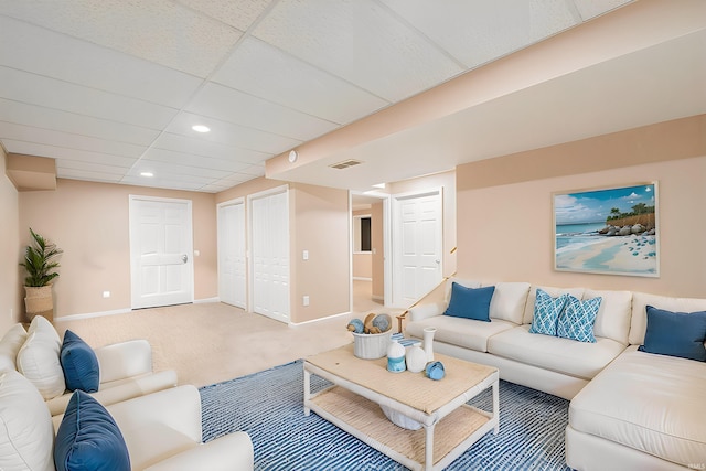 carpeted living room featuring a paneled ceiling