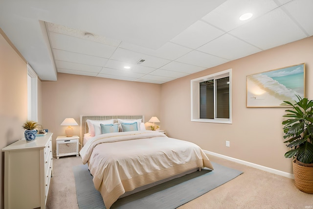 carpeted bedroom featuring a drop ceiling