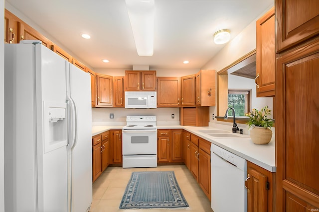 kitchen featuring light tile patterned flooring, white appliances, and sink