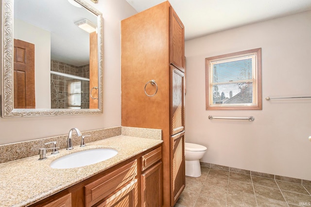 bathroom with tile patterned floors, vanity, toilet, and a shower with shower door